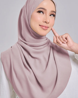 Woman wearing a pink hijab against a gray background