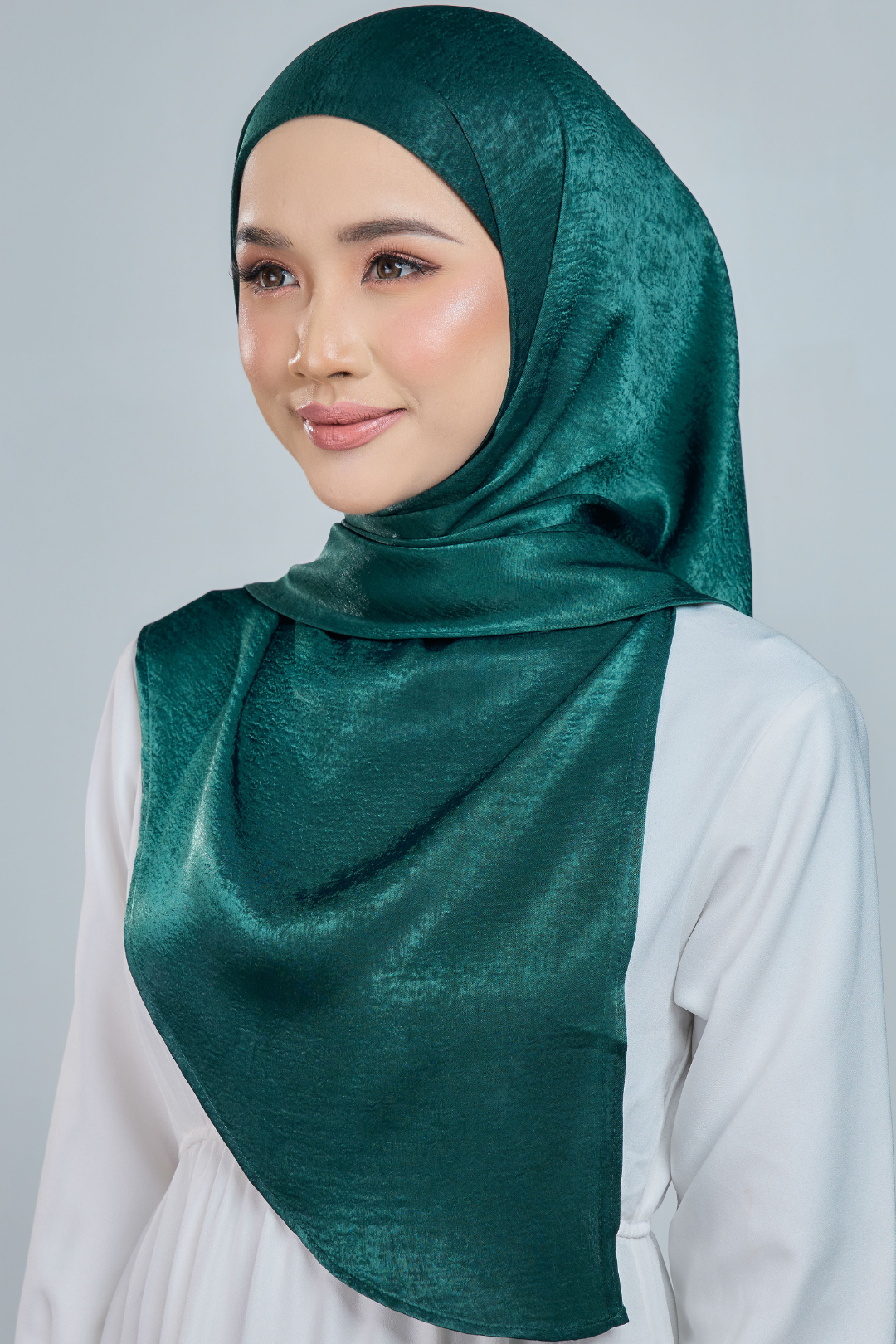 A person wearing a red half moon shaped shawl made of velvet satin with an adjustable tie back band.