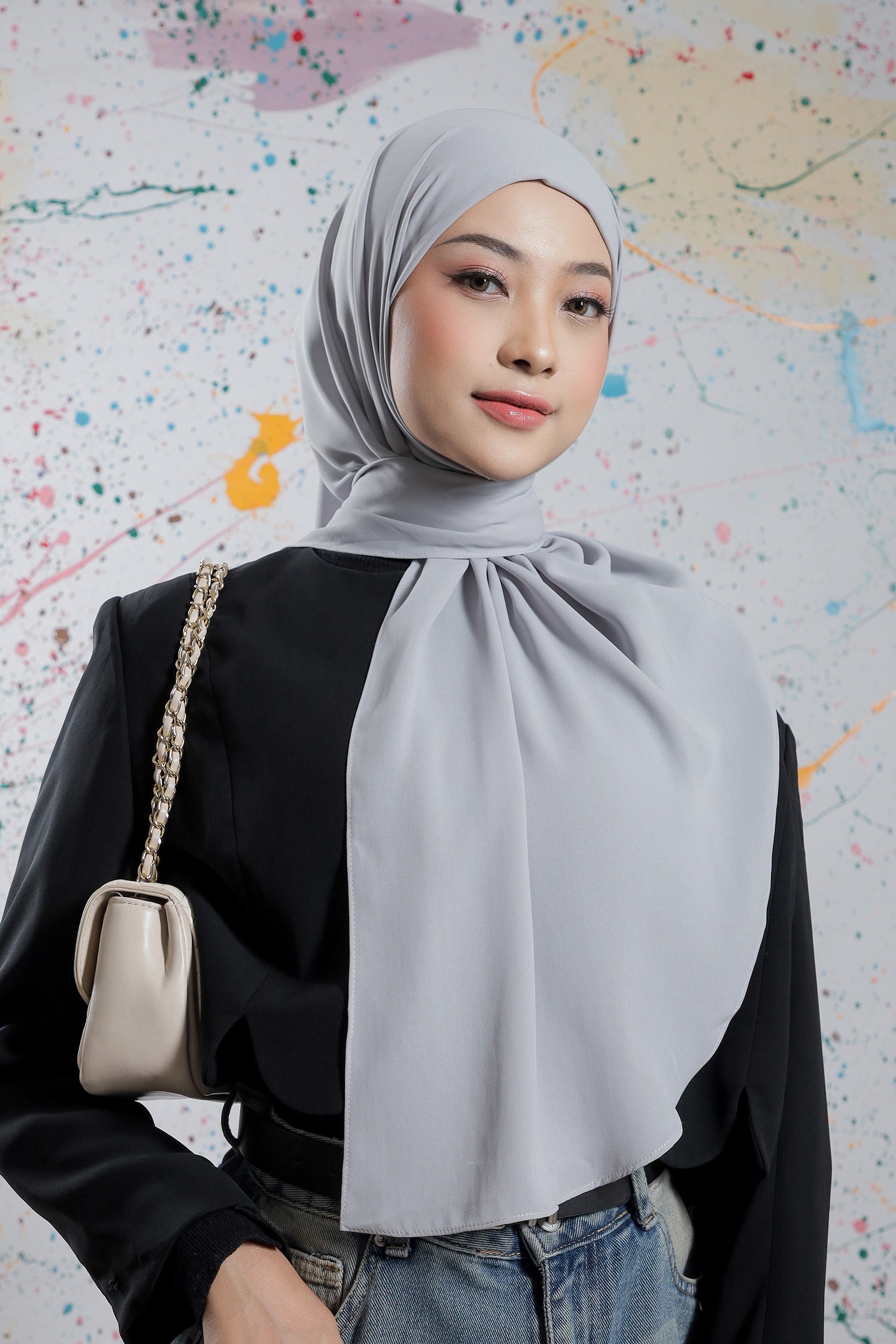 Woman wearing a gray hijab with a colorful abstract background