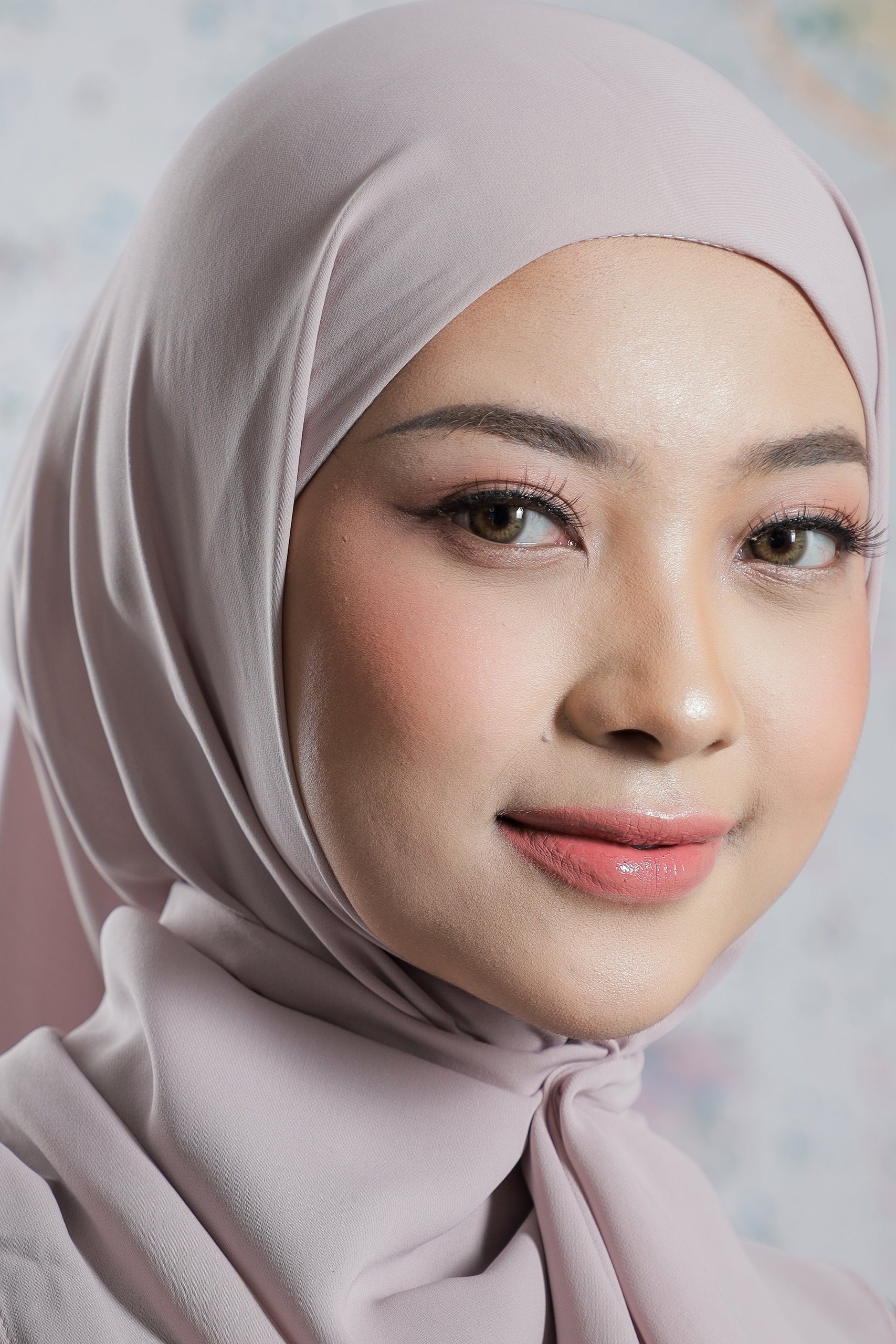 Woman wearing a light pink hijab with a blurred background
