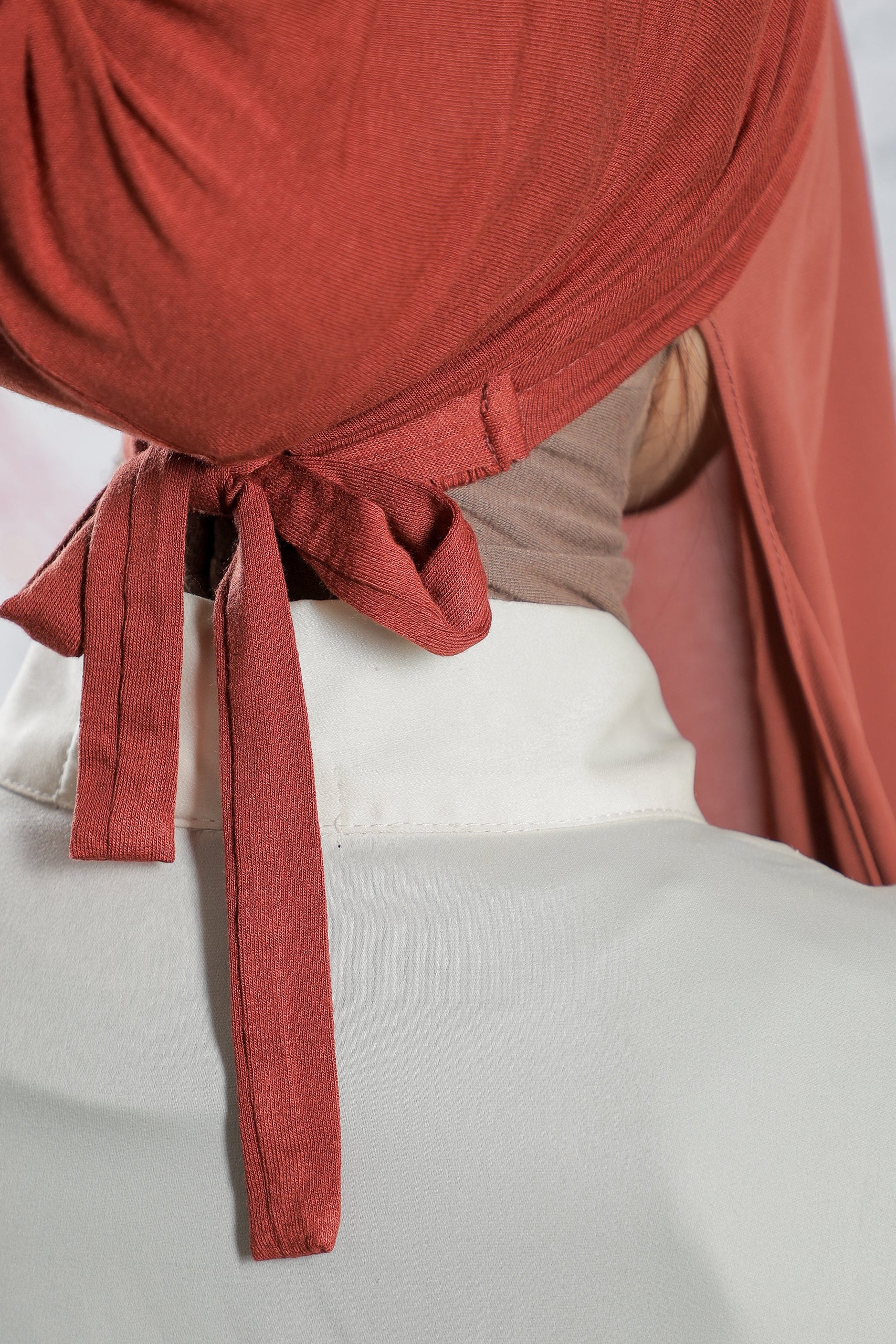 Red curtain tied back on a light gray wall