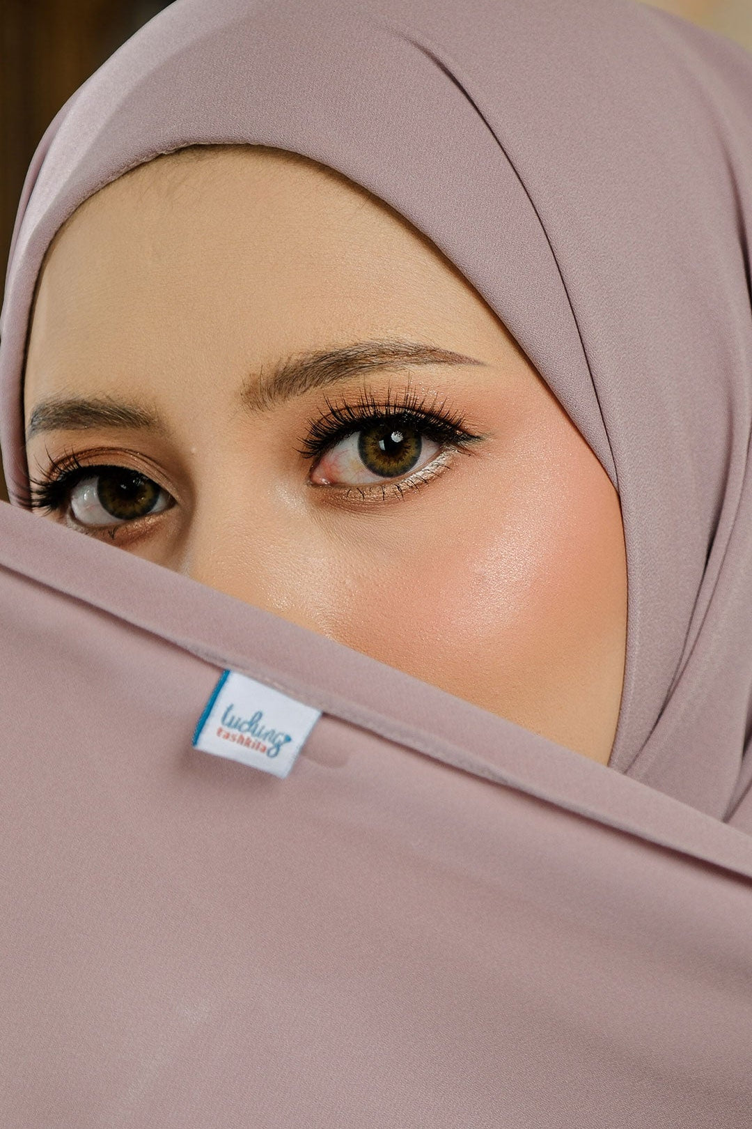 Close-up of a beige hijab with a visible brand label on a blurred background
