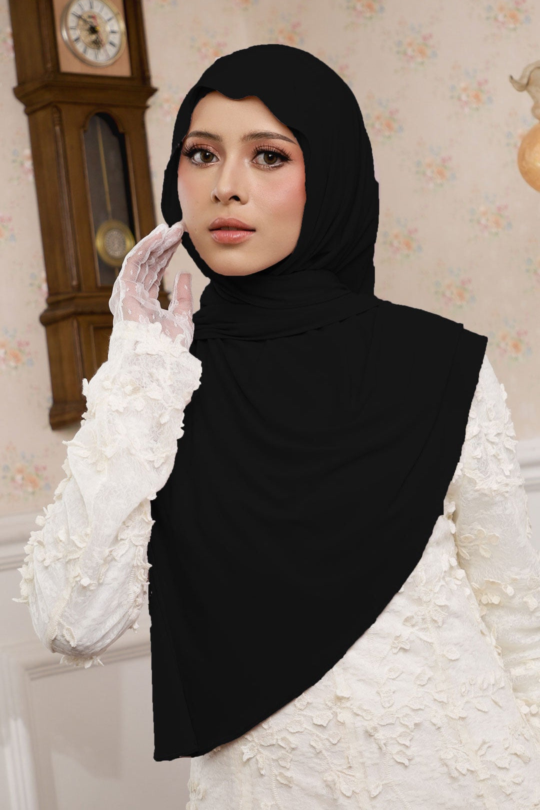 Woman wearing a black hijab and white gloves in a decorated room with a clock.