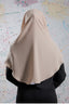 Person wearing a beige hijab against a colorful abstract background