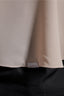 Close-up of a beige fabric with a brand label on a dark background