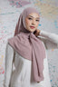 Woman wearing a pink hijab against a colorful abstract background