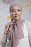 Woman wearing a pink hijab against a colorful abstract background