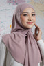 Woman wearing a pink hijab against a colorful abstract background