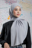 Woman wearing a gray hijab against a colorful abstract background