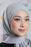Woman wearing a light gray hijab with a blurred background