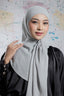 Woman wearing a light gray hijab against a colorful abstract background