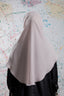 Person wearing a beige hijab against a colorful abstract background