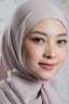 Woman wearing a light pink hijab with a blurred background